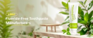 A tube of fluoride-free toothpaste surrounded by green leaves, with text highlighting "5 Best Fluoride Free Toothpaste Manufacturers."